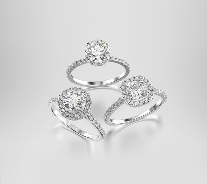 3D illustration three different white gold or silver diamonds rings with reflection on a grey background